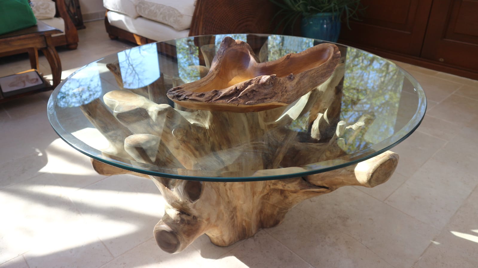 Akar Coffee Table with hand-carved teak bowl resting on the glass surface