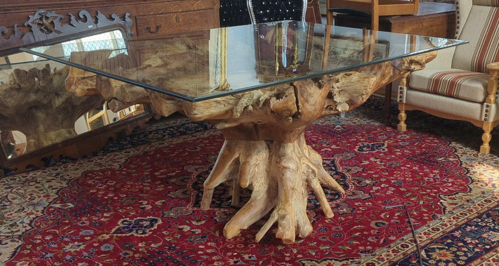 Akar Rectangle Table set in natural light with sculpted root base and floating glass top