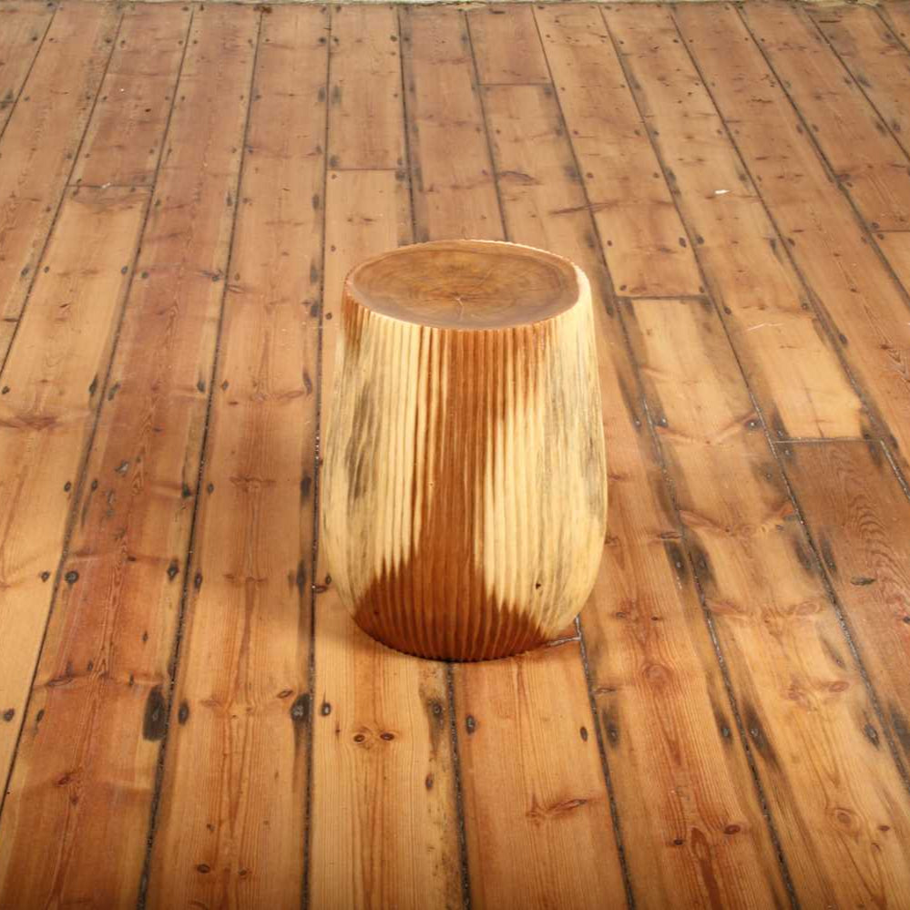Side angle showing Alur Stool’s soft taper and hand-textured sides