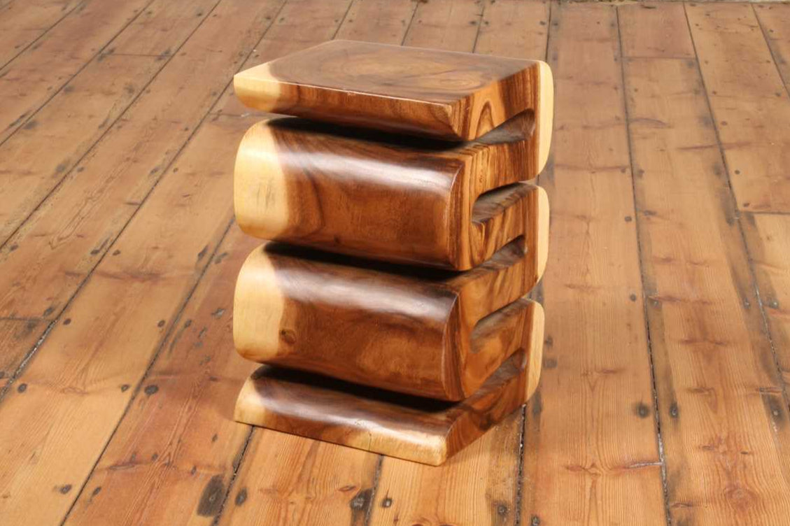 Side profile of the Arus Stool with smooth carved curves and tonal contrast.