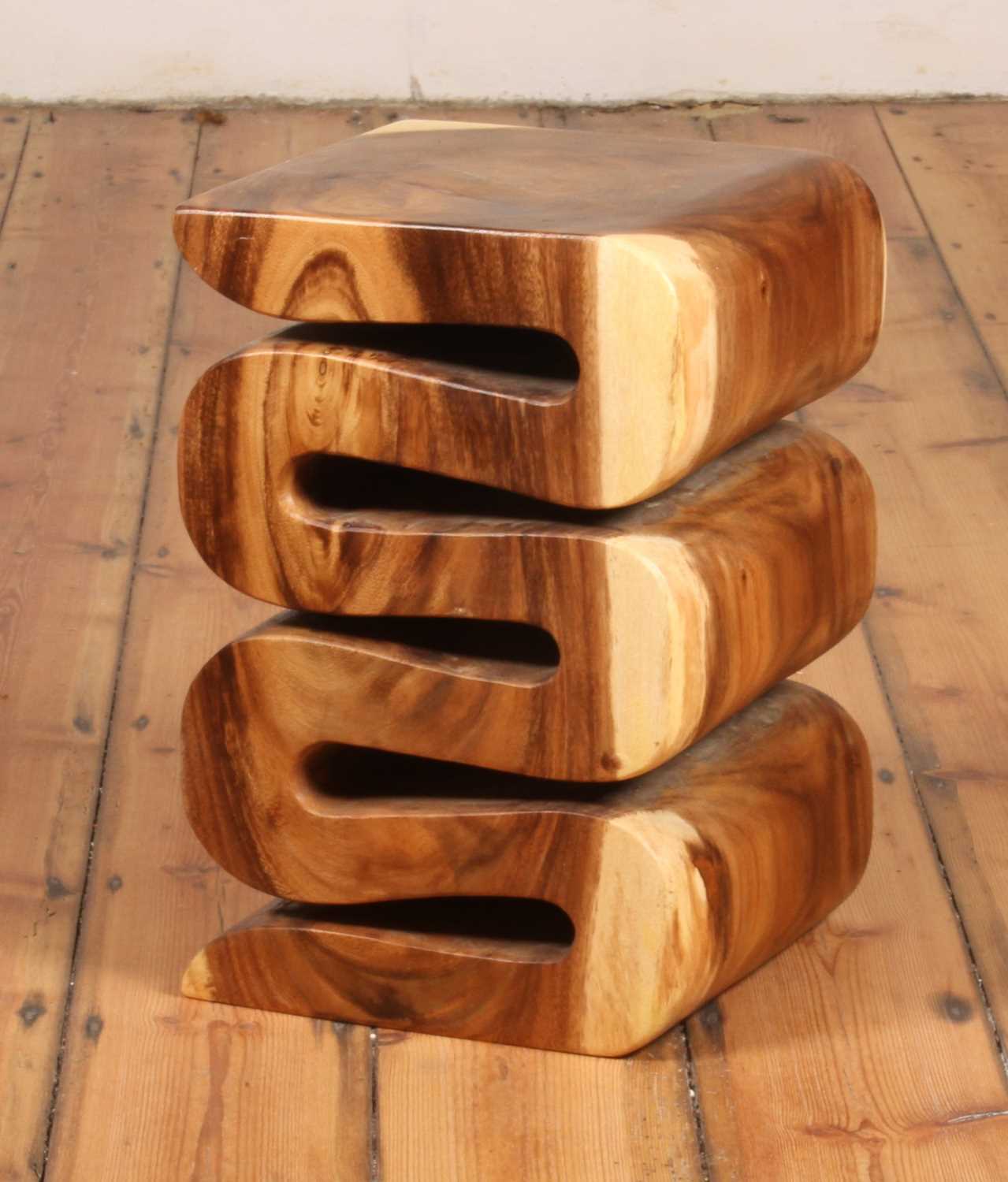 Arus Stool seen from a three-quarter view, placed on a wooden floor.