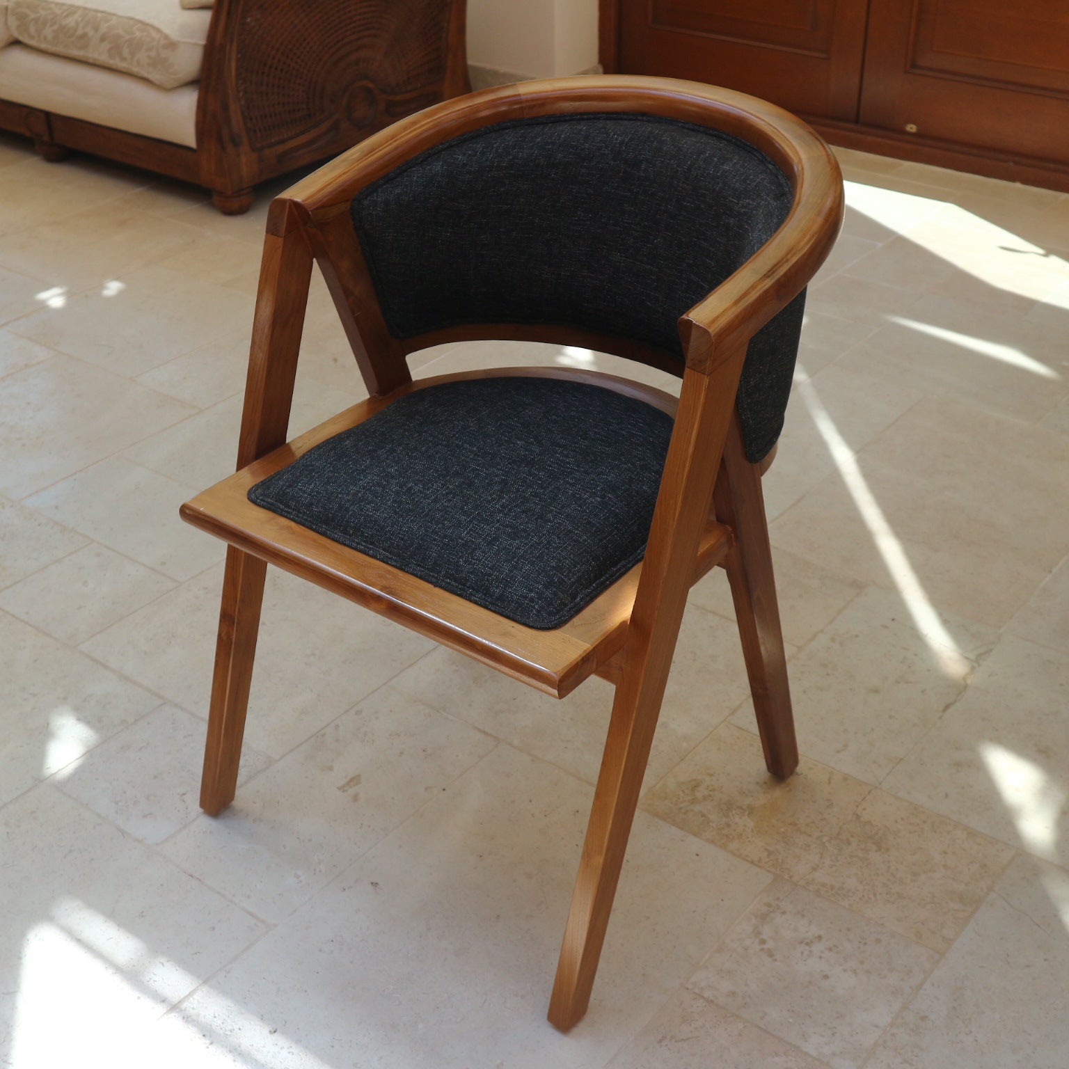 Lengkung Chair front view showing curved teak back and charcoal seat