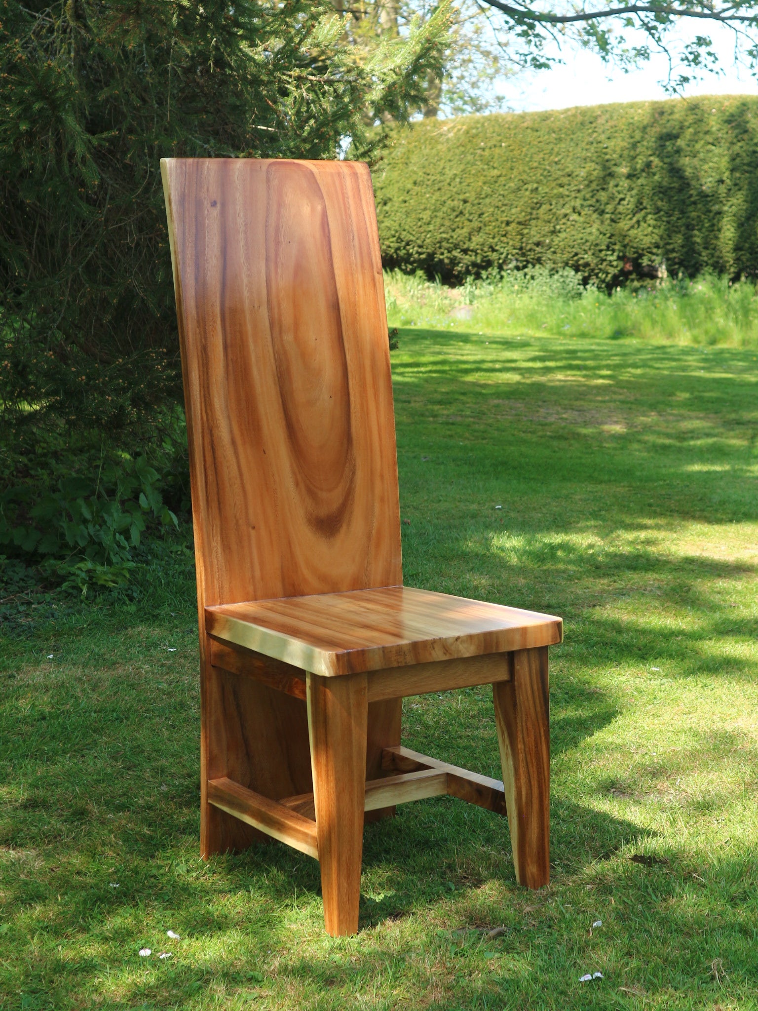 Front view of the Monolit Chair showing tall solid teak backrest and seat