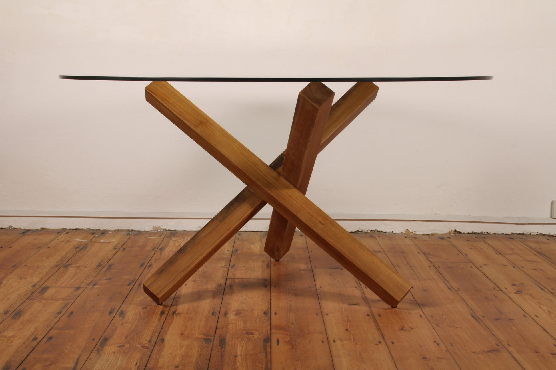 Side angle showing X-form teak structure under glass tabletop