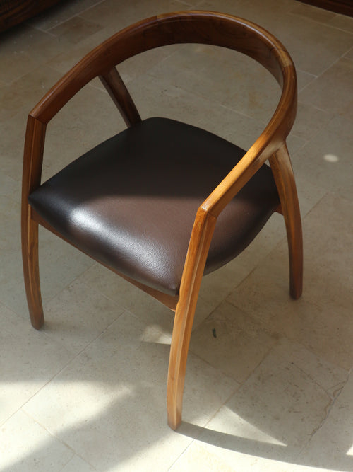 Top view of Lingkar Chair’s wraparound teak frame and leather-style cushion